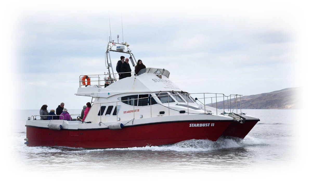Red and white boat with people on it sailing in calm waters.